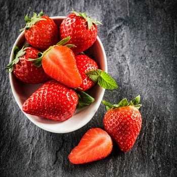 Fresh new image of strawberries on a slate background in square format with copyspace.