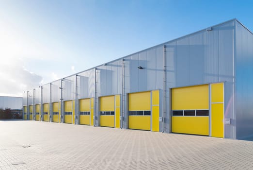 exterior of a commercial warehouse with yellow roller doors
