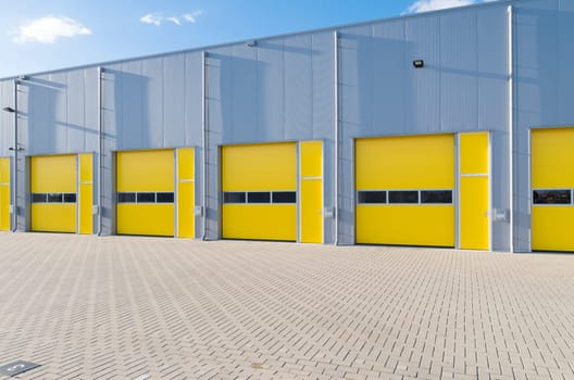 exterior of a commercial warehouse with yellow roller doors