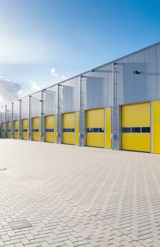 exterior of a commercial warehouse with yellow roller doors