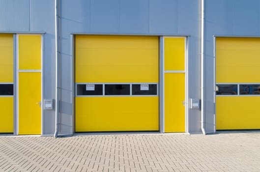 exterior of a commercial warehouse with yellow roller doors