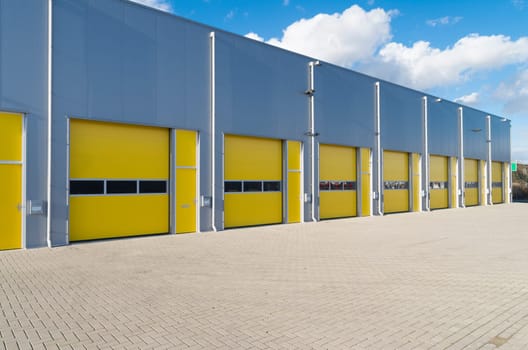 exterior of a commercial warehouse with yellow roller doors