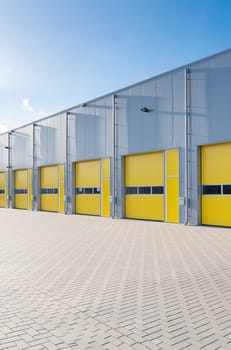 exterior of a commercial warehouse with yellow roller doors