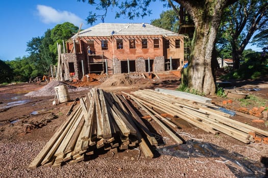 House building construction on open grounds for upstairs downstairs home with hardware raw materials on landscape grounds