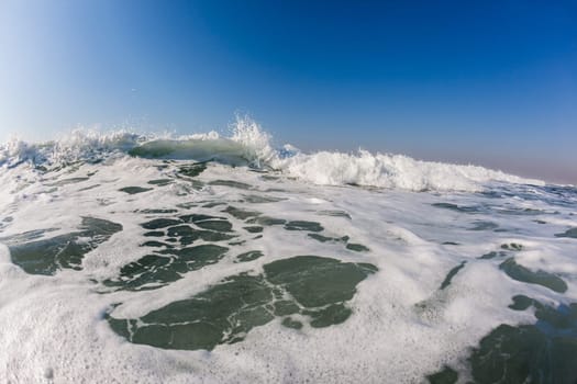 Ocean wave lip water crashing towards shallows with power energy of nature