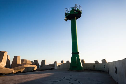 Morning dawn on the harbor pier beacon lights at the entrance into the open ocean seas