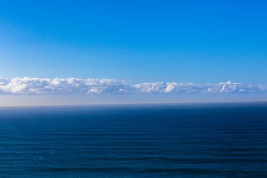 Overlooking birds eye view of blue ocean sea swells and clouds on horizon