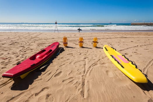 Lifeguard equipment surf rubber boat paddle skis on ocean beach sands for rescue emergancy
