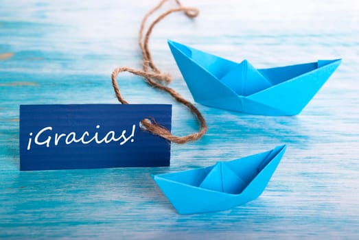 Label with the Spanish Word Gracias which means Thanks and Two Boats in the Background