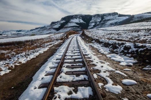 Rail-Tracks in winter snow in the valley mountain landscape