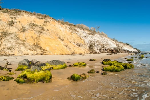 Rainbow beach color sands and rocks alongside ocean sea embankment