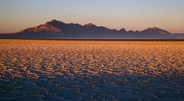 The evening sun melts the snow first turning the flats gold at sunset