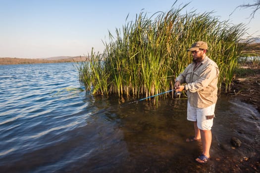 Bass fisherman afternoon by dam waters