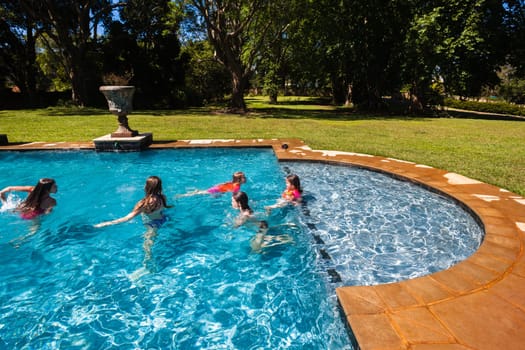 Girls cousins teenagers in home swimming pool playtime outdoors summer