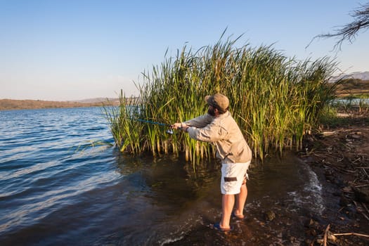 Bass fisherman afternoon by dam waters