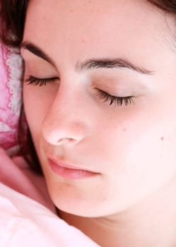 Beautiful young woman sleeping on bed in her bedroom at home in the morning.