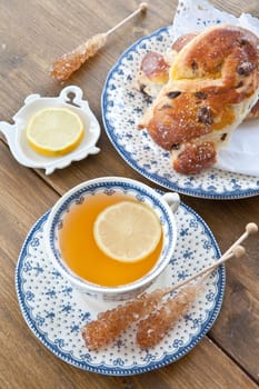 A cup of tea with lemon on rustic wooden background