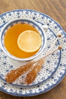 A cup of tea with lemon on rustic wooden background