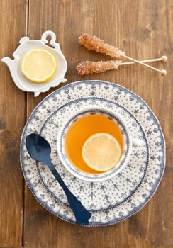 A cup of tea with lemon on rustic wooden background