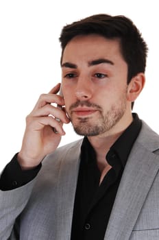 A young man talking on a cell phone in a black shirt and red tie with a beard,.isolated for white background..