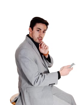 A young man holding on a cell phone in a black shirt with a beard, looking.very scared, isolated for white background..