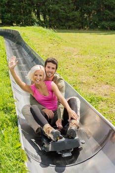Portrait of happy young couple enjoying summer sledge ride
