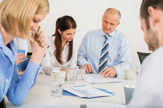 Business team discussing document in boardroom meeting