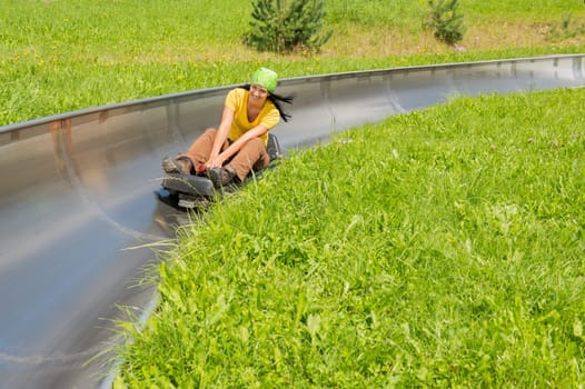 Young woman enjoying summer sledge ride