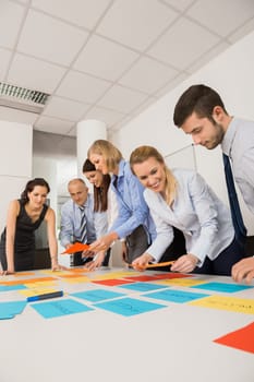 Business colleagues brainstorming with multicolored labels planning strategy in meeting