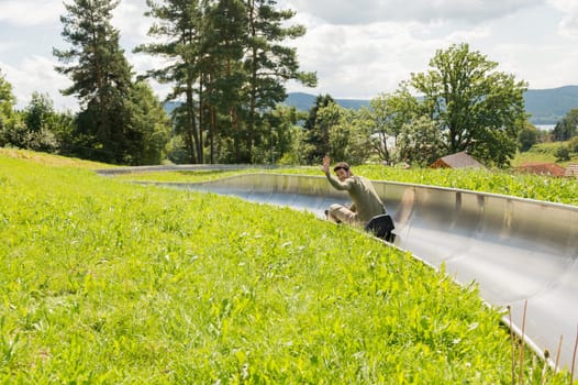 Young man enjoying summer sledge ride