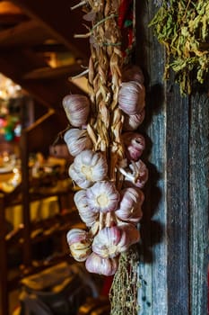 garlic bulbs hanging on wooden beam.