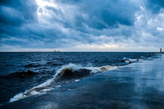 breakwater and stormy weather,with visible rough sea,waves,threatening dark sky.