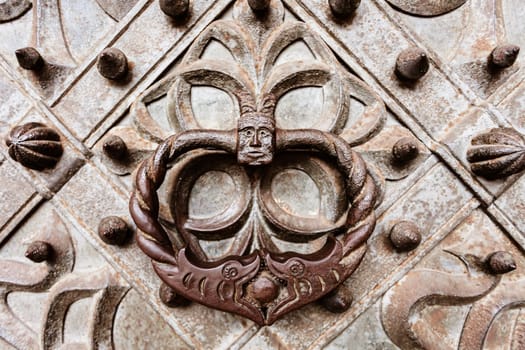Old style metal door knocker,visible on old metal ornamented gate door.