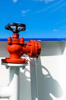 red water or fuel valve against white background. part of a fire safety system installation.