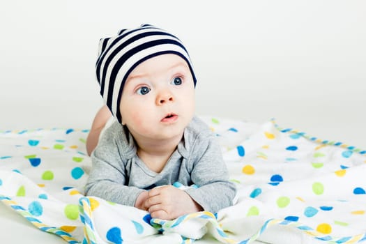 Funny cute blue-eyed baby. Little boy astonished