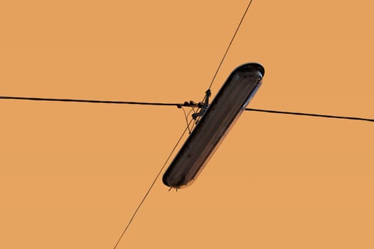 The photograph of a hanging,insulated street lamp.