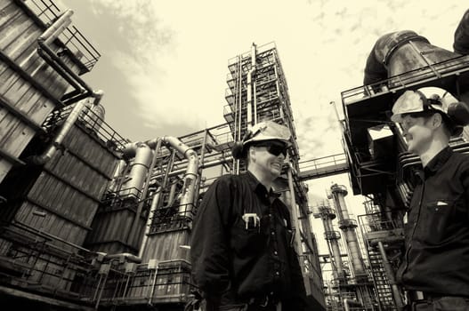 two oil and gas workers inside large oil and gas refinery, petrochemical industry