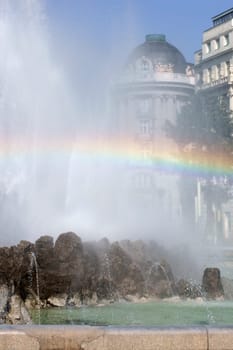 A photograph of a rainbow in the water of a fountain.