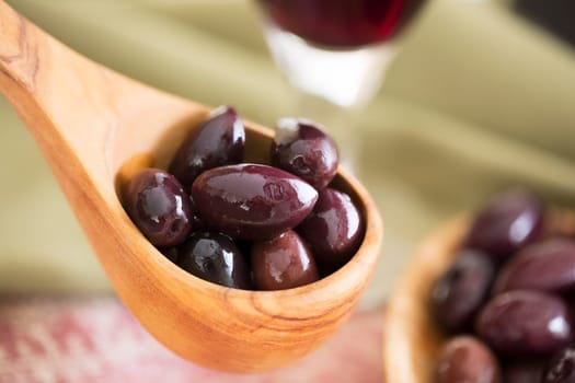 Wooden scoop of kalamata olives.