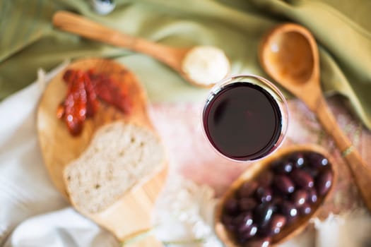 Red wine in glass from directly above with tapas out of focus on table.