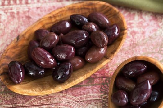 Wooden bowl and scoop of kalamata olives