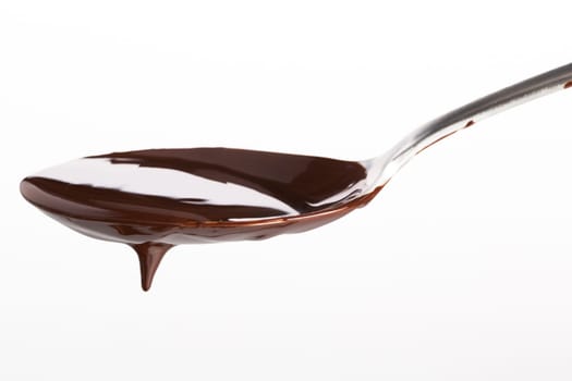 Spoon of melted chocolate topping on white background