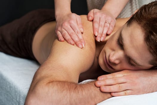 Young man getting massage in the beauty salon