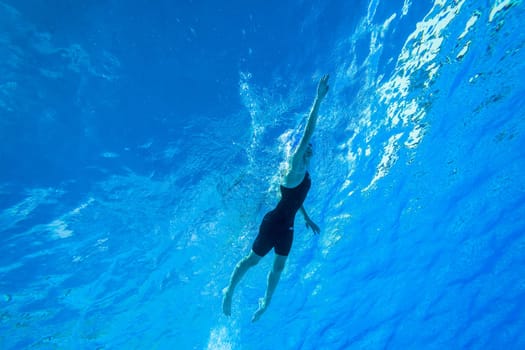 Swimmers girls boys warm-up laps before race heats.Underwater swimming water action at national championships.