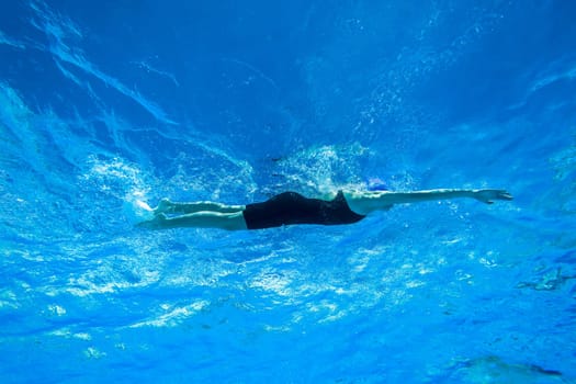 Swimmers girls boys warm-up laps before race heats.Underwater swimming water action at national championships.
