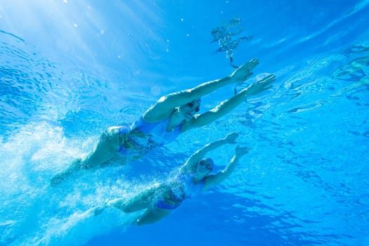 Girls Synchronized underwater swimming water action at national championships