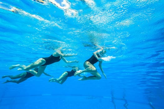 Girls Synchronized underwater swimming water action at national championships