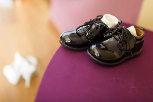 Photo presents black elegant court shoes with visible socks, in the background visible blurred woman's shoes.