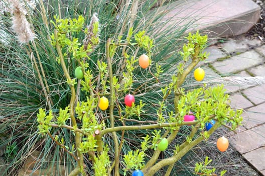 A flowering shrub in the garden adorned with Easter eggs is simply part of Easter