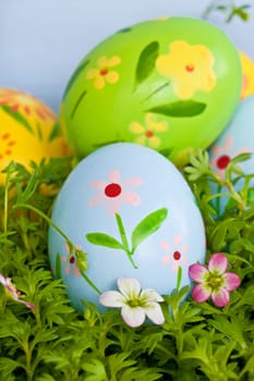 Colorful Easter eggs on grass with small blueten,detail